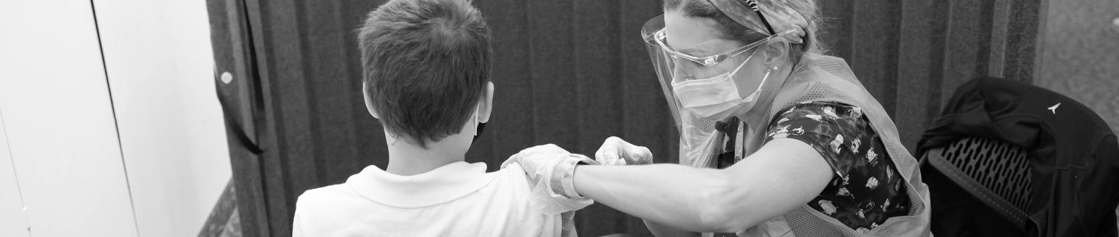A nurse giving a child a vaccine.