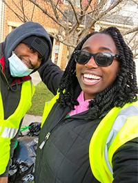 Photo of two people smiling and wearing reflective vests