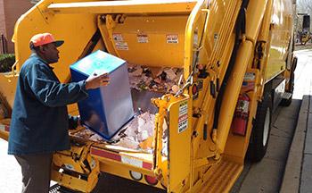 Baltimore County waste worker dispensing waste into truck.